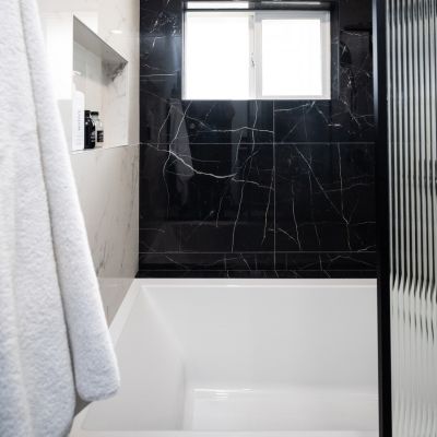 bathroom shower remodel with black shower tile accent wall
